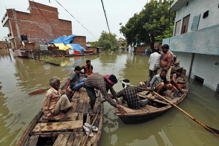 People on boats try to reach a safer ground after the overflowing of the Ganges River following heavy monsoon rains in Salori.
