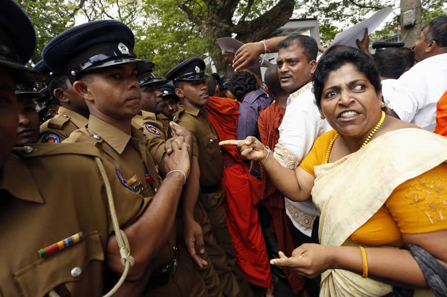 Sri Lankan police officers try to stop members of the pro-government hardline Buddhist group known as Ravana Balaya, or Ravana Force, during a protest outside the U.N. office in Colombo, Sri Lanka.