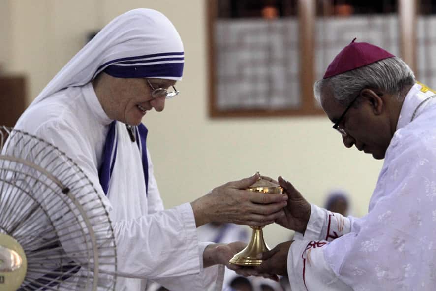 Thomas D`Souza, archbishop of Kolkata receives the holy urn from Missionaries of Charity Superior General Sister Mary Prema during a special mass marking the birth anniversary of Mother Teresa in Kolkata.