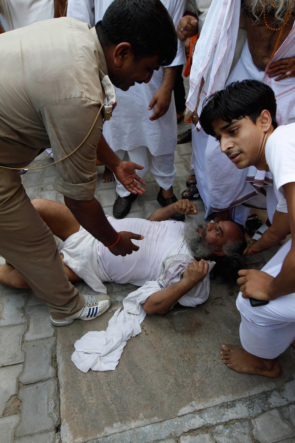 A policeman, left, detains an activist, on ground, of the nationalist organization Vishva Hindu Parishad (VHP) or World Hindu Council in Ayodhya.