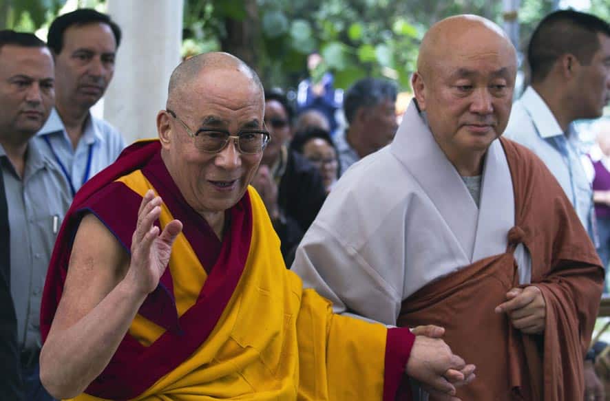 Tibetan spiritual leader the Dalai Lama, greets devotees as he arrives at the Tsuglakhang temple to give a religious talk in Dharmsala.
