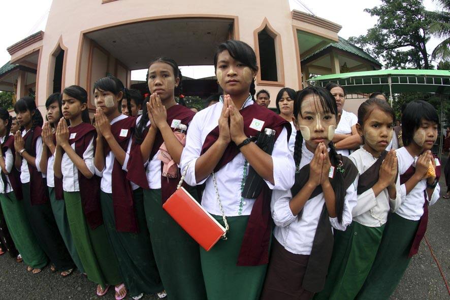 Myanmar Buddhist devotees pray during a religious day ceremony at a monastery on the outskirts of Yangon, Myanmar.