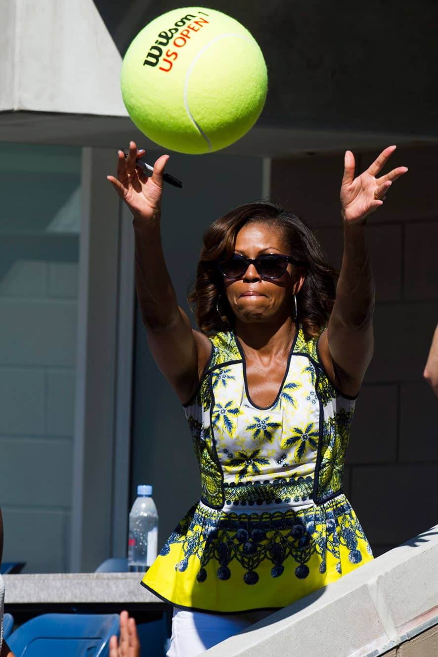 First Lady Michelle Obama catches a fan`s novelty tennis ball during the 18th Annual Arthur Ashe Kids’ Day, the kick off to the 2013 US Open tennis tournament.