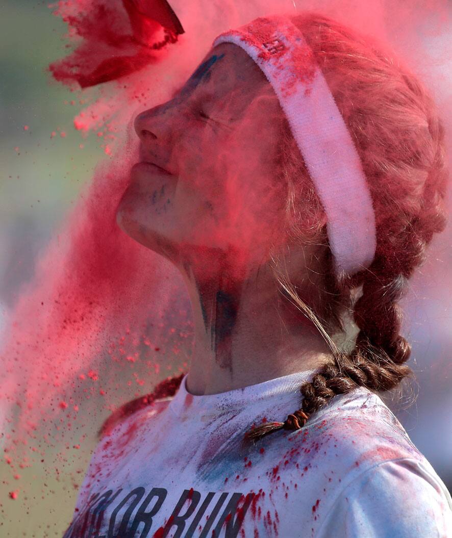 Color powder is squirted onto a participant in The Color Run in Sydney, Australia. About 3,000 kilograms (6,613 pounds) of colored corn starch is flung at the 15,000 runners over the 5 km (3.1 mile) course through Centennial Park.