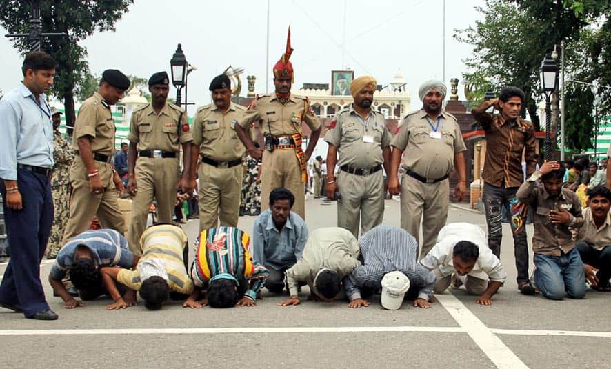 Indian fishermen, released from Pakistani jails, kneel and touch the ground in an act of reverence after crossing over to the Indian side of the border at the India-Pakistan border post of Wagah.