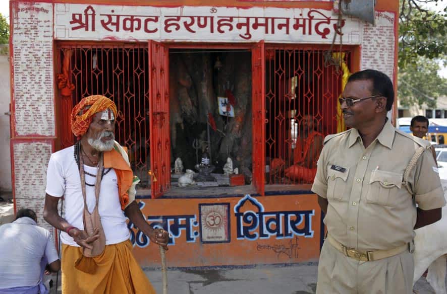 An Indian police officer talks to a Hindu holy man as he stands guard near a temple in Ayodhya.