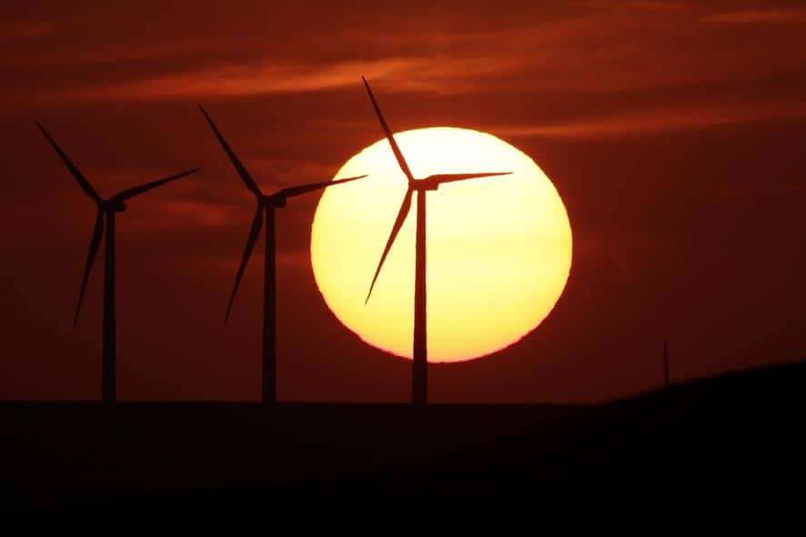 Wind turbines are silhouetted by the setting sun, near Beaumont, Kan. The turbines are part of the 100-unit Elk River Wind Farm in south central Kansas.
