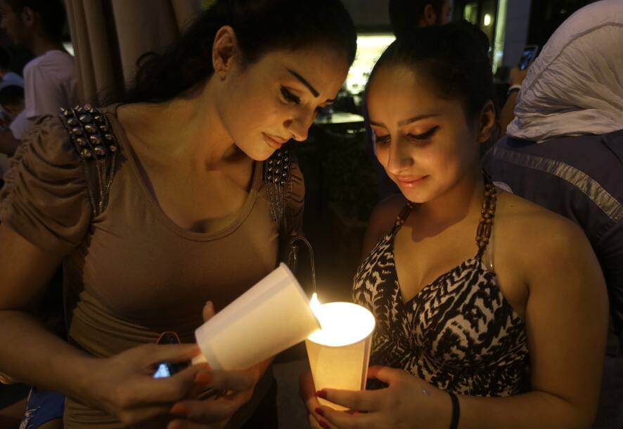 Lebanese women light candles during a vigil of Peace festival held by the Lebanese Red Cross in Downtown Beirut, Lebanon.