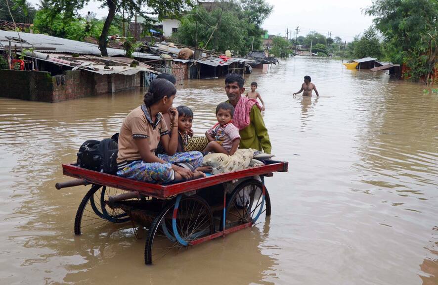 Village children sit on a cart as they are moved to safer areas after their homes were submerged in floodwaters in Hoshangabad in the central Indian state of Madhya Pradesh.