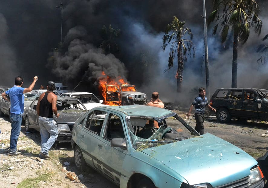 Lebanese men gather at the site of an explosion outside of a mosque, in the northern city of Tripoli, Lebanon.