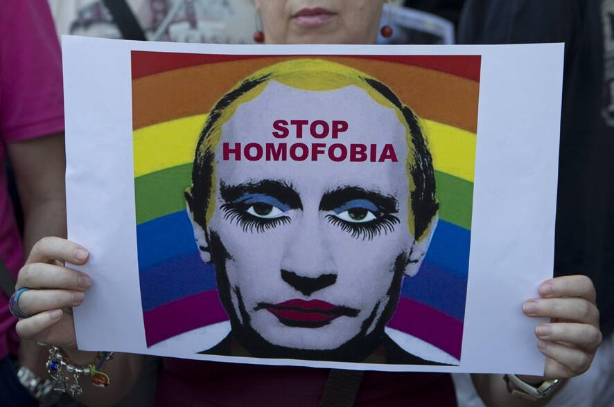 A woman holds a poster depicting Russian President Vladimir Putin during a protest in front of the Russian embassy in Madrid, Spain against Russia`s new law on gays.