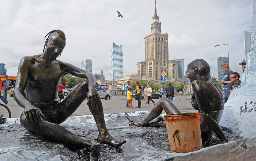 Greenpeace activists sit on a stage resembling ice, with oil spread over their bodies, protesting against oil search drilling in the Arctic Sea in Warsaw, Poland.