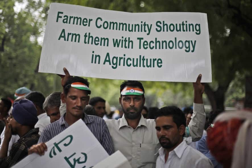 A farmer holds a placard as they listen to a speaker during a rally near the parliament in New Delhi. The farmers appealed to policy makers for infusion of technology to increase productivity and sustenance of agriculture.