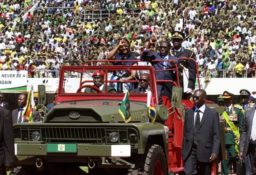 Zimbabwean President Robert Mugabe and his wife Grace greet the crowd as they arrive for his inauguration in Harare.