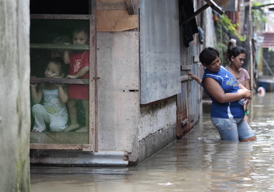 Filipino children stay inside their house surrounded by floodwaters on the banks of the swollen Laguna lake in Laguna province, southern Philippines.