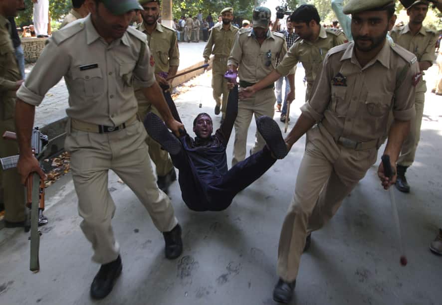 Jammu and Kashmir Policemen detain a Kashmiri government employee during a protest in Srinagar.