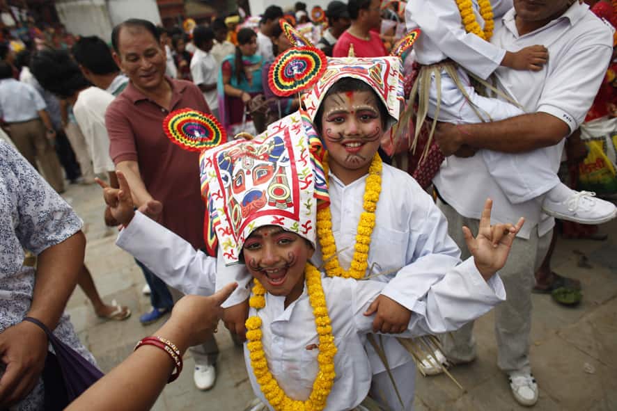 Nepalese Hindu boys in festival attire react to cameras during
