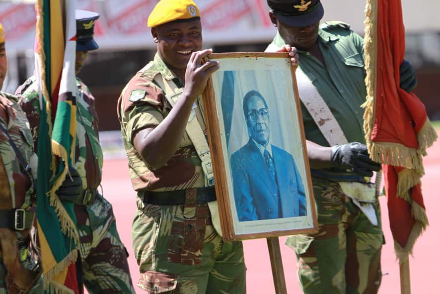 A soldiers holds a portrait of Zimbabwean President elect, Robert Mugabe during rehearsals for his inauguration in Harare.