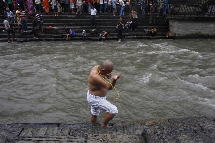 A Nepalese Hindu wears the Janai, or sacred thread, across his chests during Janai Purnima, or Sacred Thread festival, on the bank of the Bagmati River near Pashupati temple in Katmandu, Nepal.