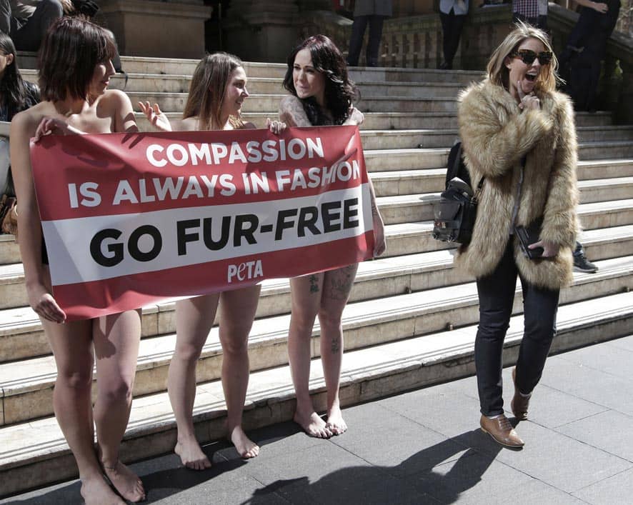 A passer-by, appears to mock anti-fur protesters Tanya Ward, Zoe Crawford and Jacqui House, who have stripped to their underwear in an attempt to persuade clothing designers to stop using animal fur in Sydney, Australia.