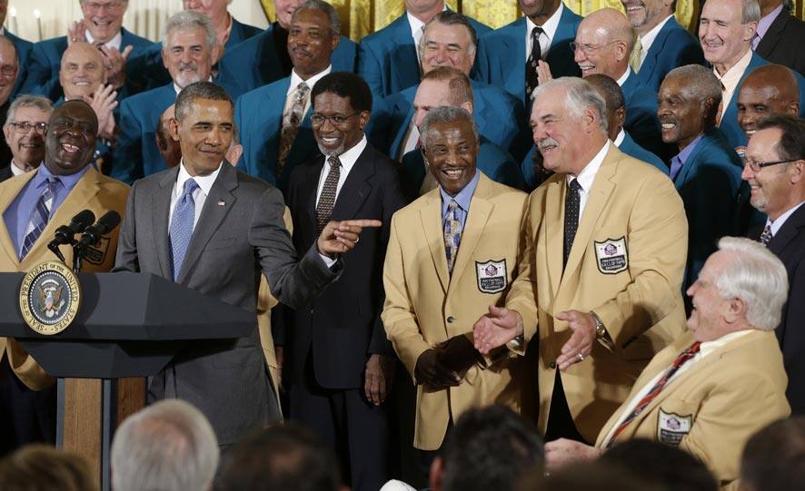 President Barack Obama points to Hall of Fame coach Don Shula, far right seated, during a ceremony in the East Room of the White House in Washington.