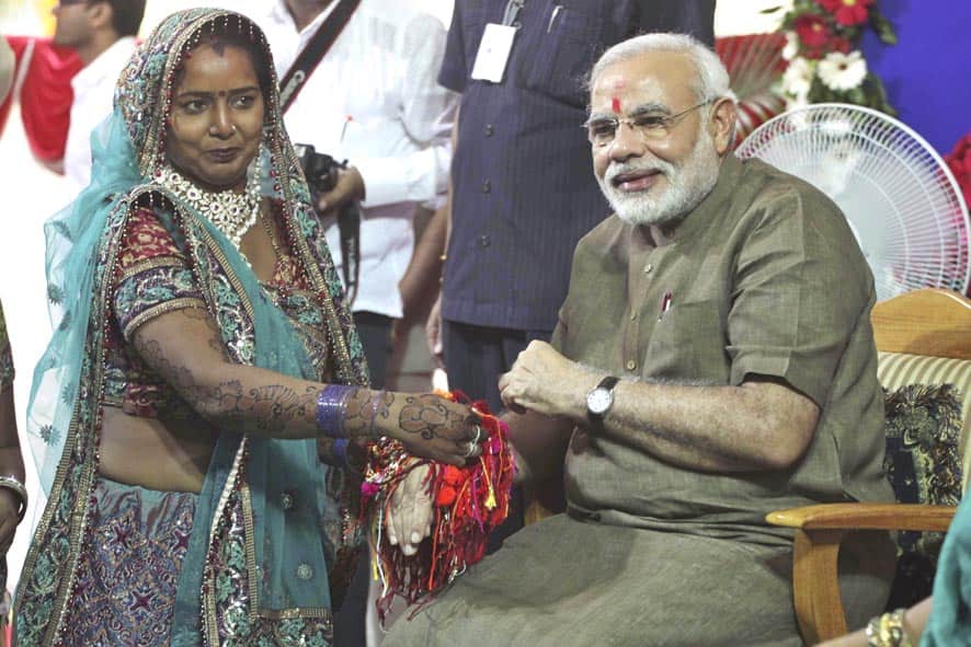 Woman ties Rakhi or sacred thread on the wrist of Gujarat chief minister Narendra Modi on Raksha Bandhan festival in Gandhinagar.