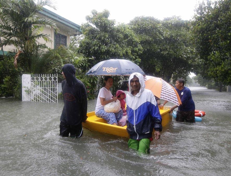 Volunteers rescue residents trapped in a flooded street at a subdivision in Makati city, east of Manila, Philippines.