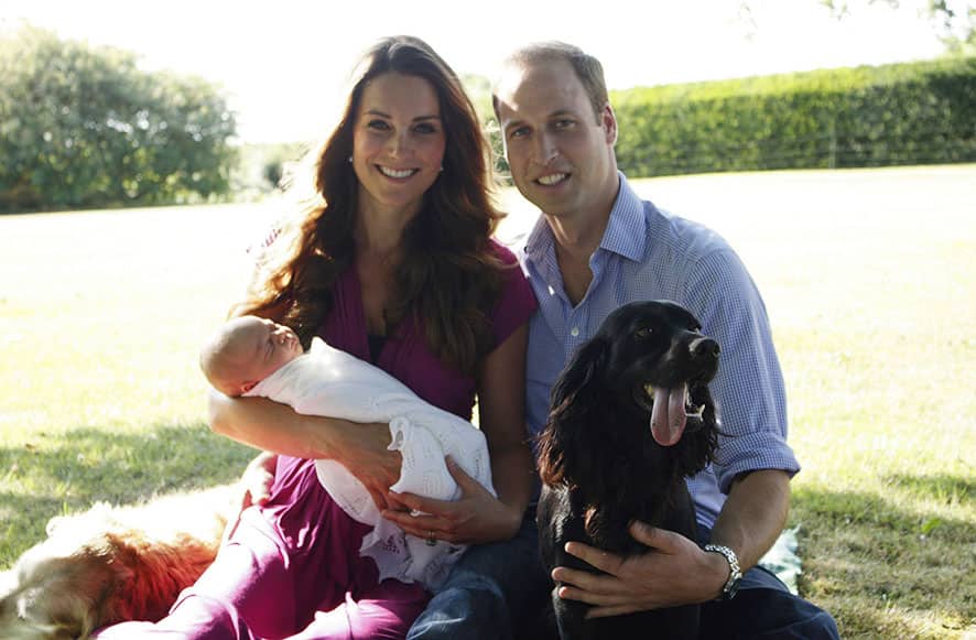 This image shows the Duke and Duchess of Cambridge with their son, Prince George, in the garden of the Middleton family home in Bucklebury, England, with Tilly the retriever, seen left, a Middleton family pet, and Lupo, the couple`s cocker spaniel.