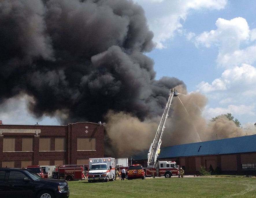 At least six buildings in an aging industrial complex just east of downtown Fort Wayne, Ind., went up in flames filling the sky with a plume of heavy black smoke as the blaze moving rapidly from one building to the next, sometimes aided by shifting winds.
