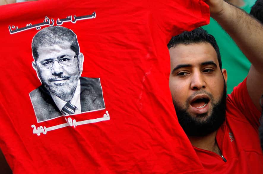 A supporter of Egypt`s ousted President Mohammed Morsi holds a T-shirt with his picture during a march in Maadi, Cairo, Egypt.