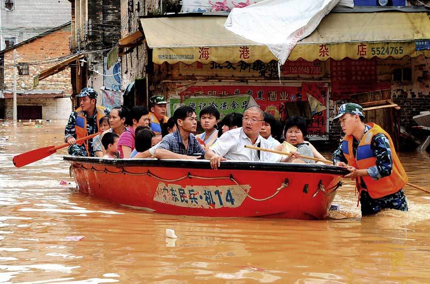 Chinese paramilitary police men evacuate residents through flood waters from typhoon Utor in Huaiji in south China`s Guangdong province.