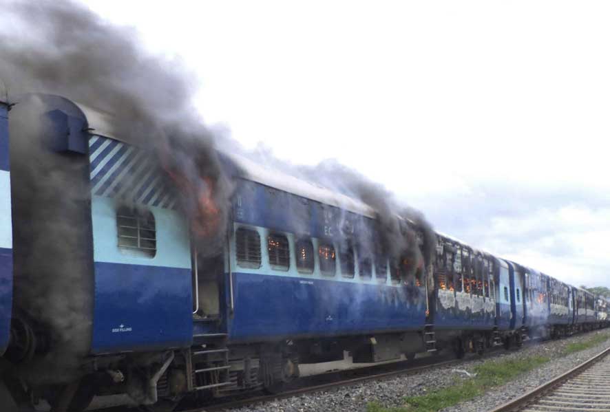 Coaches of the Rajya Rani Express train burn after a mob set it on fire as it ran over a group of Hindu pilgrims at a crowded station in Dhamara Ghat, Bihar state.