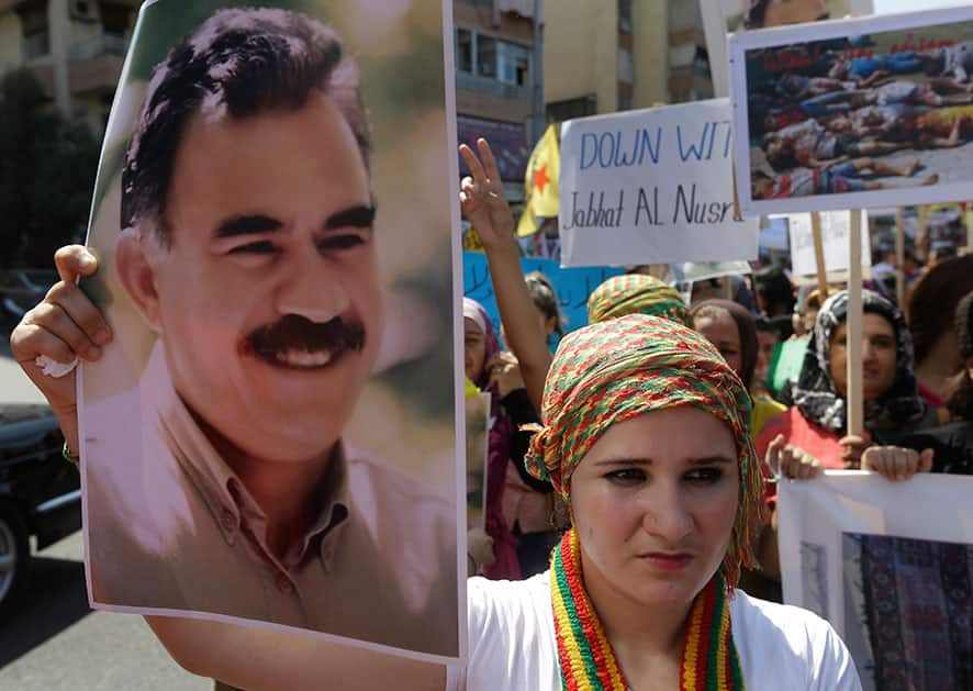 A Kurdish supporter of the Kurdistan Workers` Party, or PKK, holds a portrait of the party leader Abdullah Ocalan during their protest march against the al-Qaida-affiliated Jabhat al-Nusra in Beirut, Lebanon.