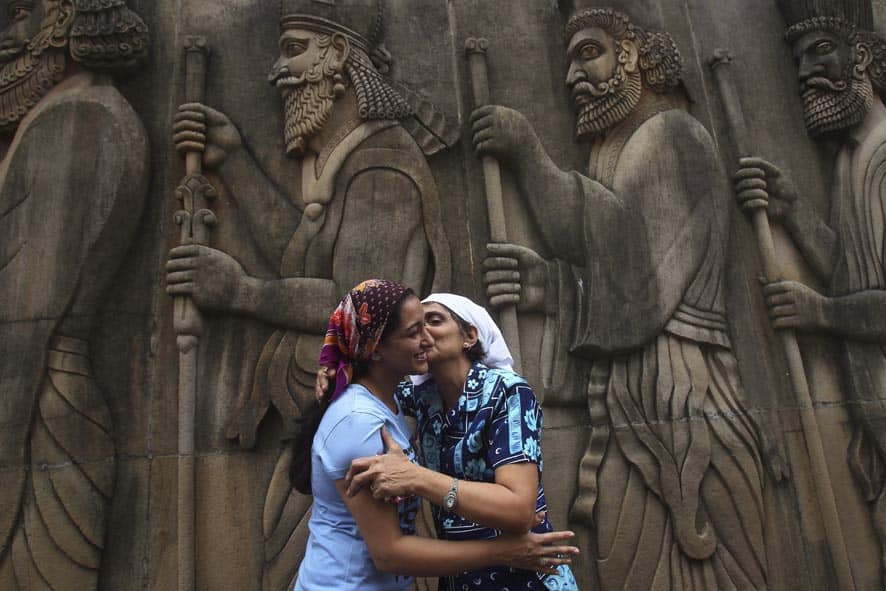 Parsis greet each other near bas-relief of ancient priests at a Fire Temple, on Navroze, the Parsi New Year, in Mumbai.