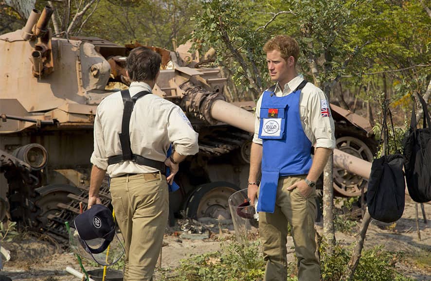 Britain`s Prince Harry, right, speaks with HALO Director Guy Willougby as they stand near a South African Olifant tank destroyed in the Battle of Cuito Cuanavale in 1988, in Angola.