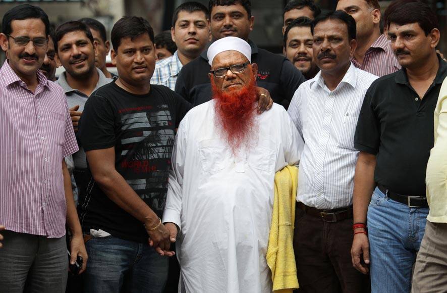Policemen in plain clothes surround Syed Abdul Karim alias Tunda, center in white cap, prior to him being escorted to court, in New Delhi.
