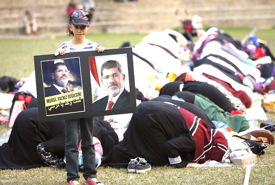 A girl holds a poster of Egypt`s ousted Islamist President Mohammed Morsi during a special prayer in Kuala Lumpur, Malaysia.