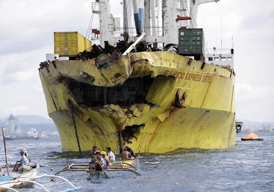 Volunteers search near the damaged cargo ship Sulpicio Express Siete a day after it collided with a passenger ferry off the waters of Talisay city, Cebu province in central Philippines.