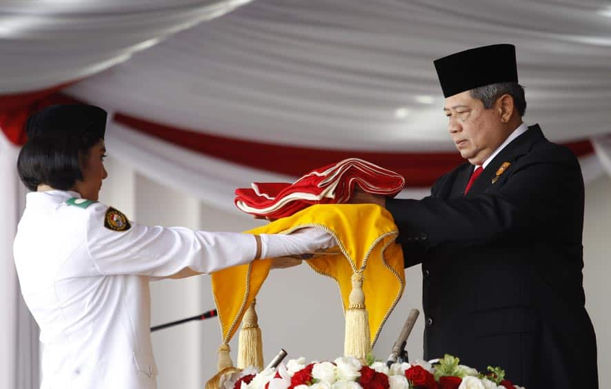 Indonesian President Susilo Bambang Yudhoyono, right, presents the national Red-White flag to a bearer to be hoisted during a ceremony commemorating the country`s independence day at Merdeka Palace in Jakarta, Indonesia.