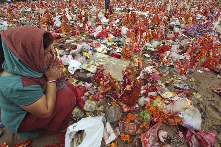 An Indian woman worships an idol of Hindu goddess Dashama before immersion in the River Sabarmati on the last day of the Dashama festival in Ahmedabad.