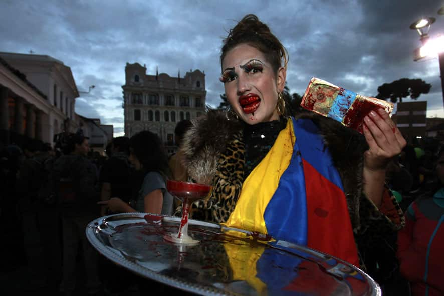 An environmental activist, with her mouth stained in fake blood, demonstrate in front of the government palace in Quito, Ecuador.