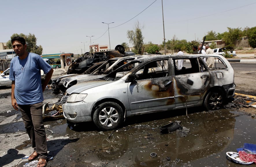 Civilians inspect the aftermath of a car bomb attack in the northern Shiite neighborhood of Khazimiyah of Baghdad, Iraq.