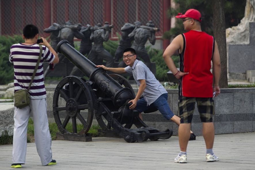 A Chinese man poses with the replica of a canon on display near Marco Polo bridge also known as Lu Gou Bridge on the 68th anniversary of the of Japan`s surrender in the 1937-1945 anti-Japan war that started from an incident near the bridge in Beijing, China.
