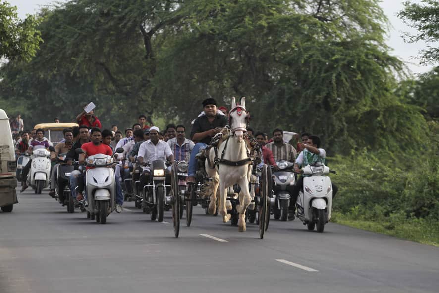 People on motorcycles follow a horse cart during its race on the outskirts of Ahmadabad. The race is held annually following Eid celebrations.