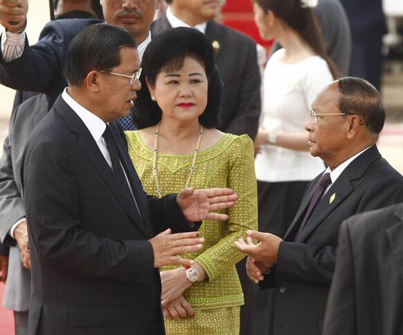 Cambodian Prime Minister Hun Sen, left, talks with National Assembly President Heng Samrin, right, as Hun Sen wife Bun Rany, center, looks on, at Phnom Penh International Airport in Phnom Penh, Cambodia.