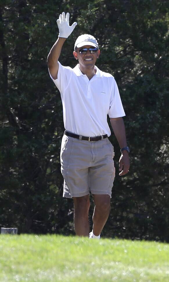 President Barack Obama waves to a group of on-lookers while golfing at Farm Neck Golf Club in Oak Bluffs, Mass., on the island of Martha`s Vineyard.