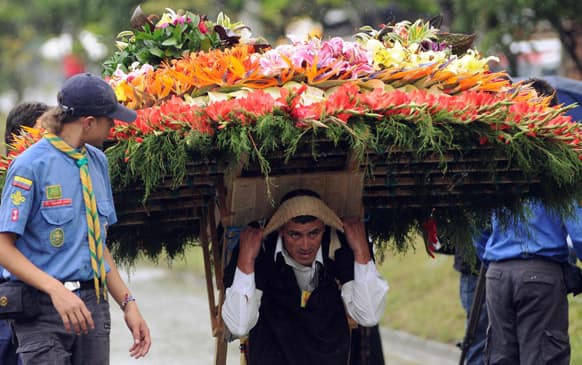 A man carries a flower arrangement on his black during the annual festival of flowers in Medellin, Colombia.