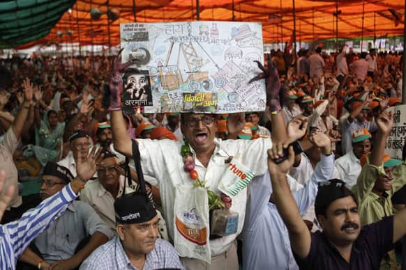 A supporter of India’s main opposition Bharatiya Janata Party (BJP) wearing a garland made of vegetables holds a placard as others shout slogans during a protest against power tariff hike in New Delhi.
