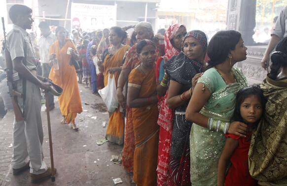 A policeman stands guard as Hindu devotees queue up to offer prayers at the Nag Vasuki Temple during the annual ‘Nag Panchami‘ festival, in Allahabad.