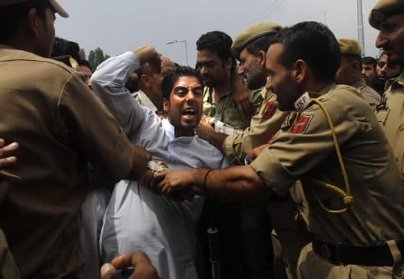 Policemen detain an activist of Awami Ittihad party during a protest rally in Jammu region in Srinagar.